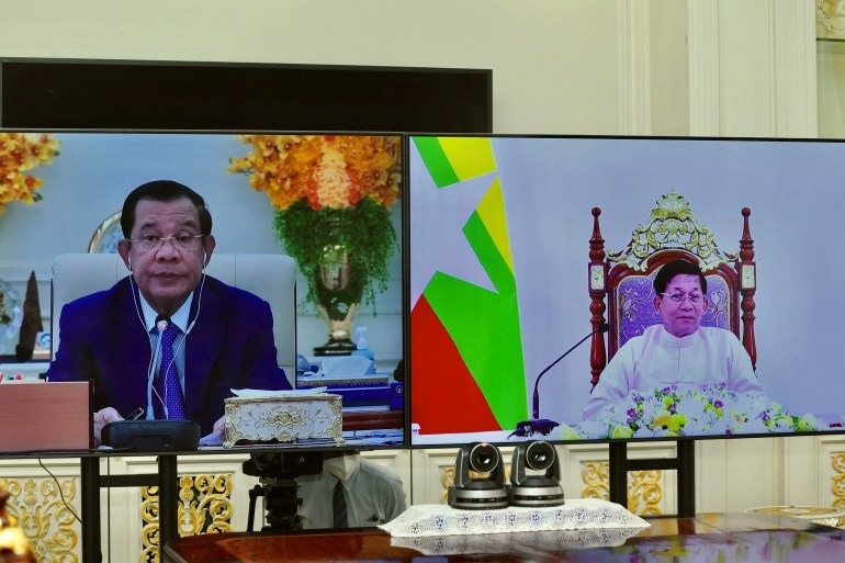 Cambodian PM Hun Sen and Myanmar coup leader Min Aung Hlaing seen on separate screens during a virtual meeting. Hun Sen is wearing a suit and blue tie while Min Aung Hlaing is sitting on a throne-like chair and wearing a traditional outfit in white