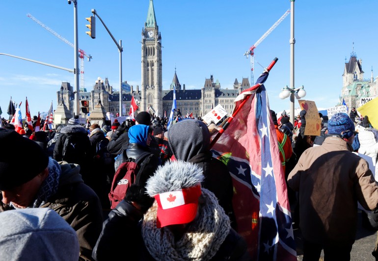 A person carries a Confederate battle flag in front of the Canadian parliament