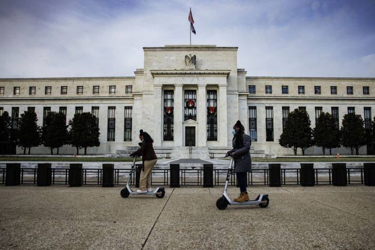Visitors ride electric scooters near the Marriner S. Eccles Federal Reserve building in Washington, D.C.
