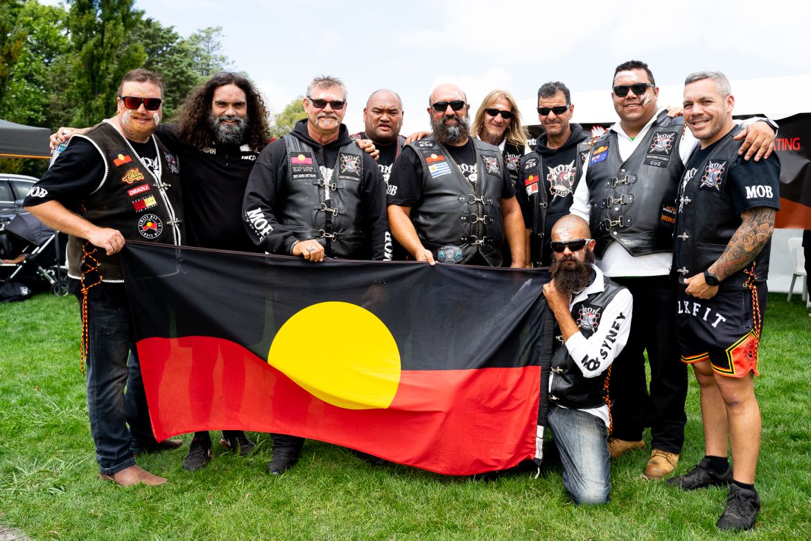Men from the MOB Sydney motorcycle club holding the Aboriginal flag.