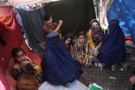 internally displaced school teacher wearing a burqa from Takhar province, who identified herself by her first name, Nilofar, left, speaks during an interview with the Associated Press inside her tent in a public park in Kabul, Afghanistan. Many women in Afghanistan remain at home