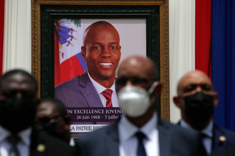 Officials standing in front of picture of assassinated Haitian president Jovenel Moise