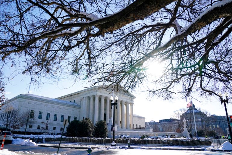 Sun shines on a snowy scene at the US Supreme Court as justices hear arguments on vaccine mandates in workplaces.