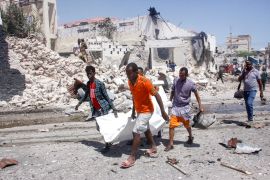 Rescuers carry away the dead body of a civilian who was killed in a blast in Mogadishu, Somalia