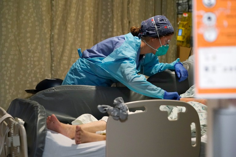 Nurse bending over a hospital bed
