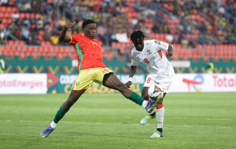 Guinea's Moriba Kourouma, left, is challenges by Gambia's Ebrima Darboe during the African Cup of Nations
