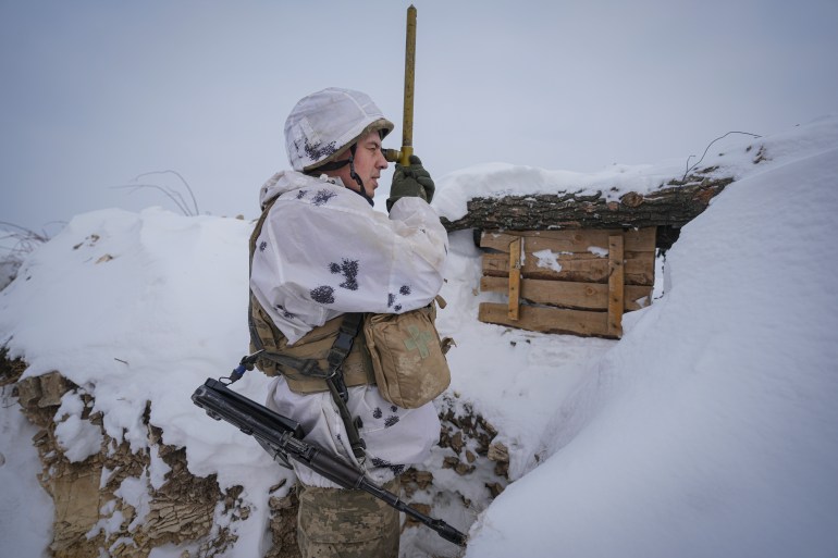 A Ukrainian serviceman is seen using a periscope in Luhansk