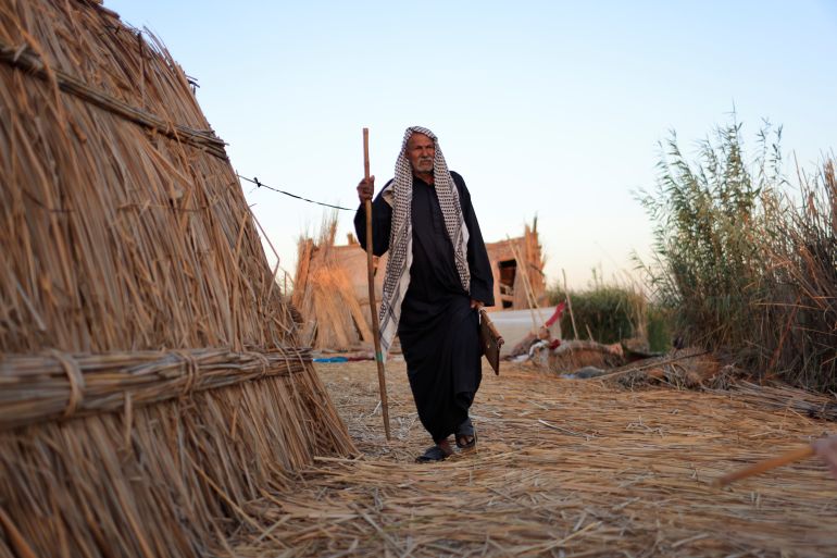 A man walks near his home in the Chebayesh marsh, Dhi Qar province in Iraq