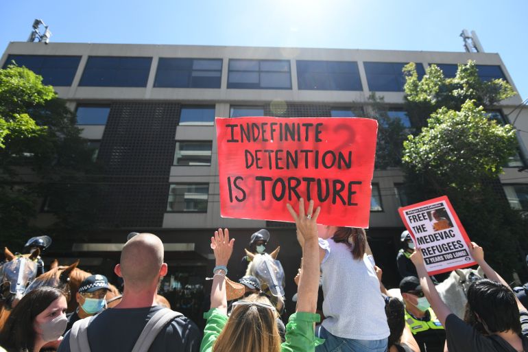 Protesters gather outside the Park Hotel in Melbourne in support of refugees held in indefinite detention after tennsi star Novak Djokovic was sent there