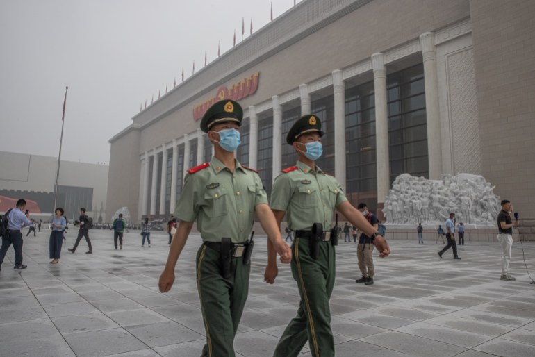 Chinese paramilitary police in summer unoforms march outside a new museum to the Chinese Commuist Party