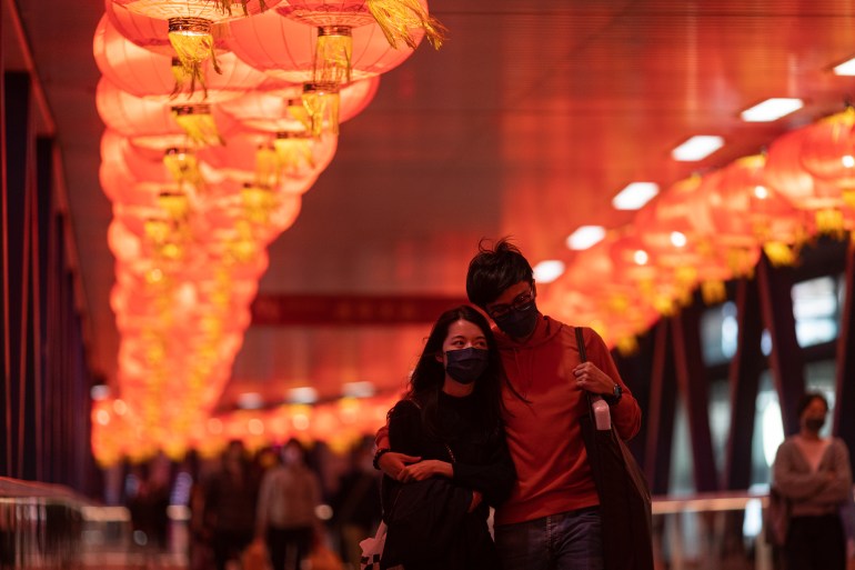 A couple walk beneath illuminated red Chinese lanterns in Hong Kong 