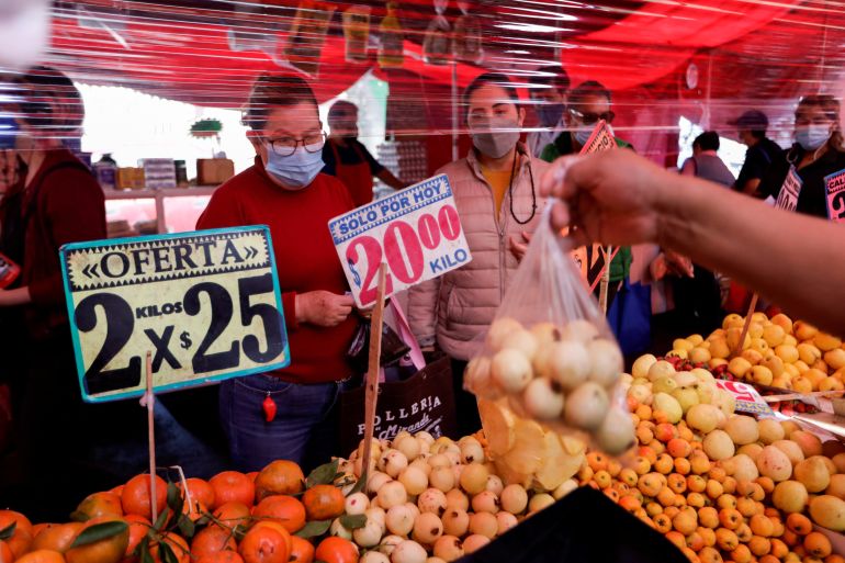 Customers buy fruit in a stall at a street market, in Mexico City, Mexico
