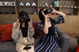 Women wearing virtual reality goggles.
