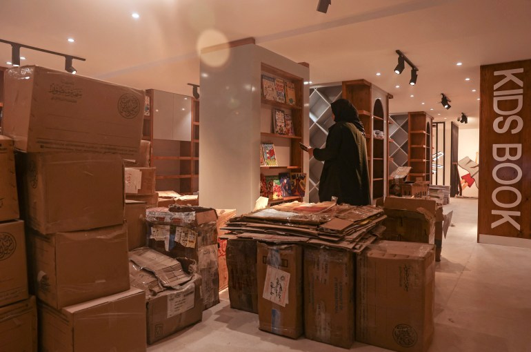 A worker packs bookshelves in a store