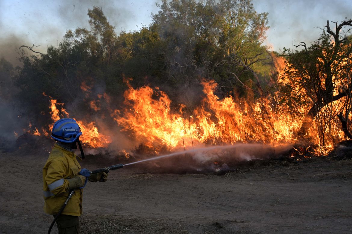 Firefighters control the burned field to fight the wildfires of native forest at Paraje Uguay