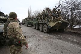 Ukranian soldiers are seen on military vehicles in Ukraine's Lugansk region