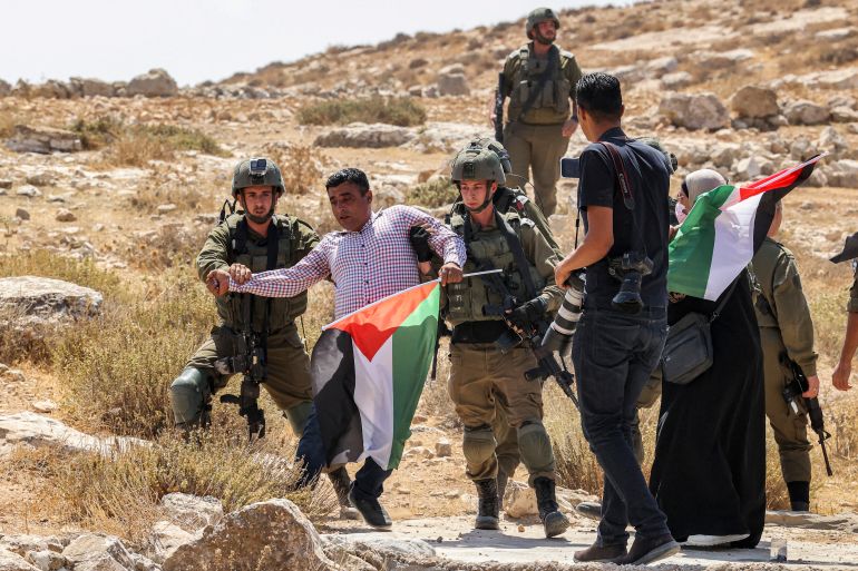 Israeli soldiers detain a Palestinian