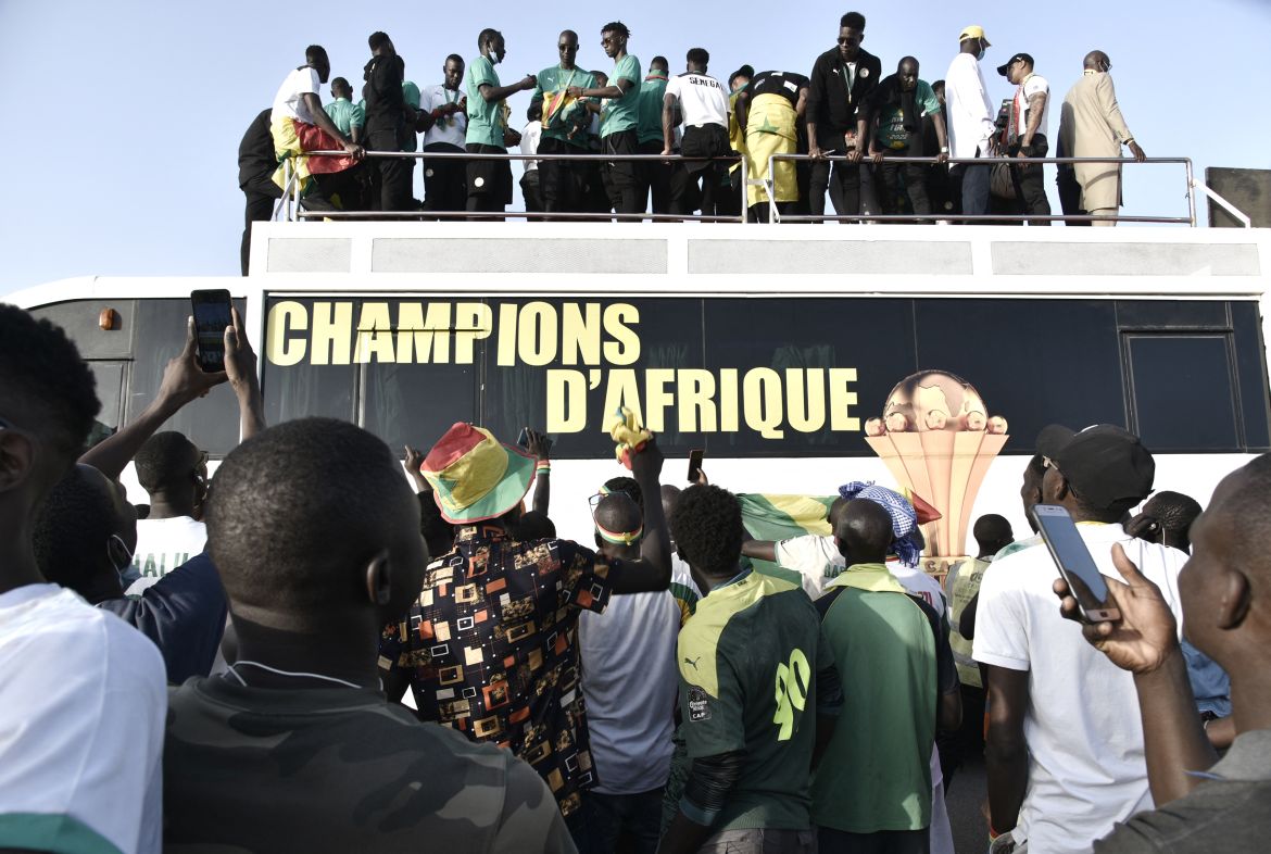 Supporters surround the bus carrying the national football team in Dakar