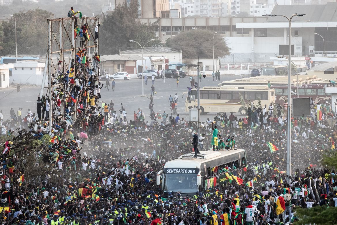 Supporters cheer as a member of the Senegalese Football team raises the trophy in Dakar