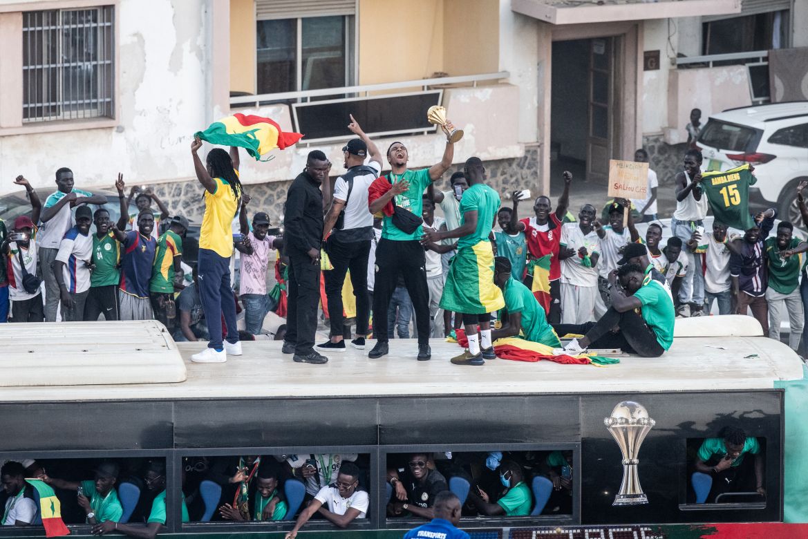 Supporters cheer as Abdou Diallo, Senegalese defender football player, raises the trophy in Dakar