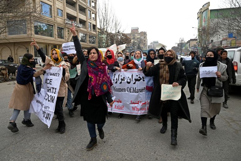 Afghan women chant slogans and hold banners during a women's rights protest march in Kabul.