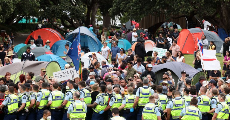 Protesters refuse to leave as police form a line at parliament grounds where they have pitched their tents