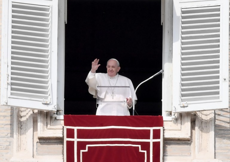 Pope Francis waves to the faithfull as he delivers the Sunday Angelus prayer from the window of his study overlooking St.Peter's Square at the Vatican