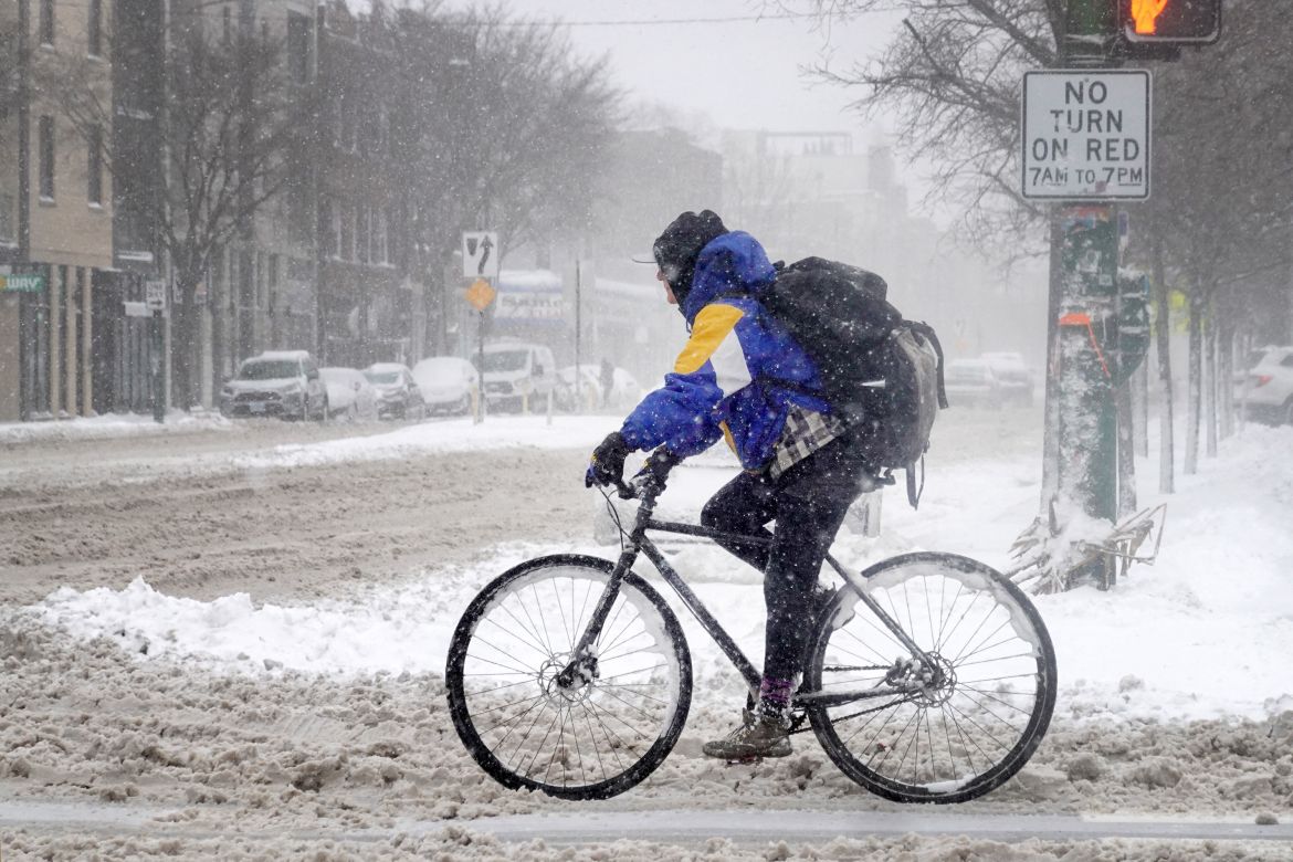 A cyclist navigates a snow-covered street