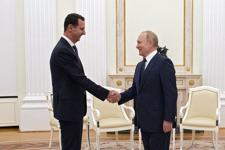 Al-Assad shakes hands with Putin