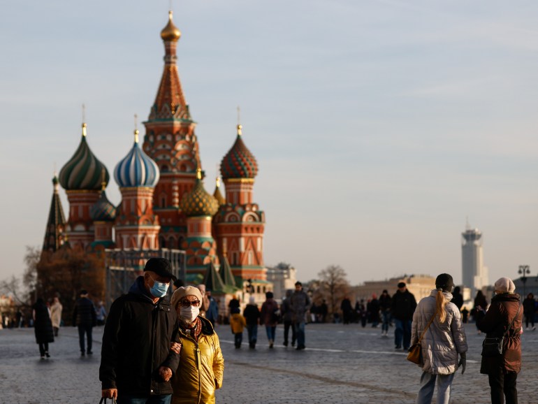 People wearing face masks are seen walking across Moscow's Red Square