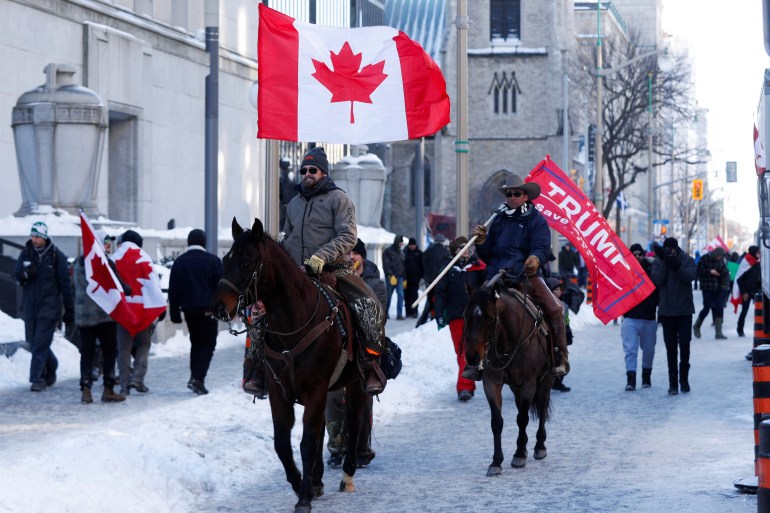 Protesters on horse back ride with flags as truckers and supporters continue to protest coronavirus disease (COVID-19) vaccine mandates, in Ottawa, Ontario, Canada, February 5, 2022.