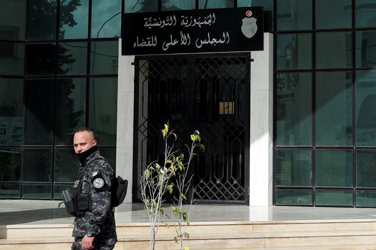 Police officer walks outside the Supreme Judicial Council building during a protest in Tunis.