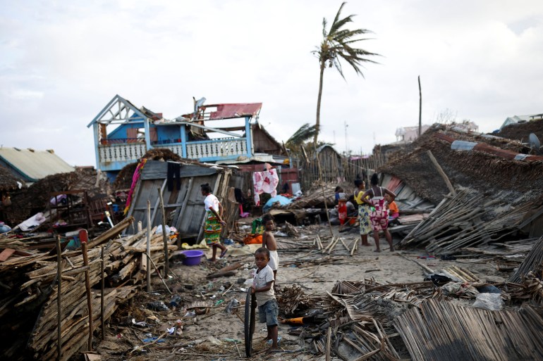 Locals stand among destroyed houses, in the aftermath of Cyclone Batsirai