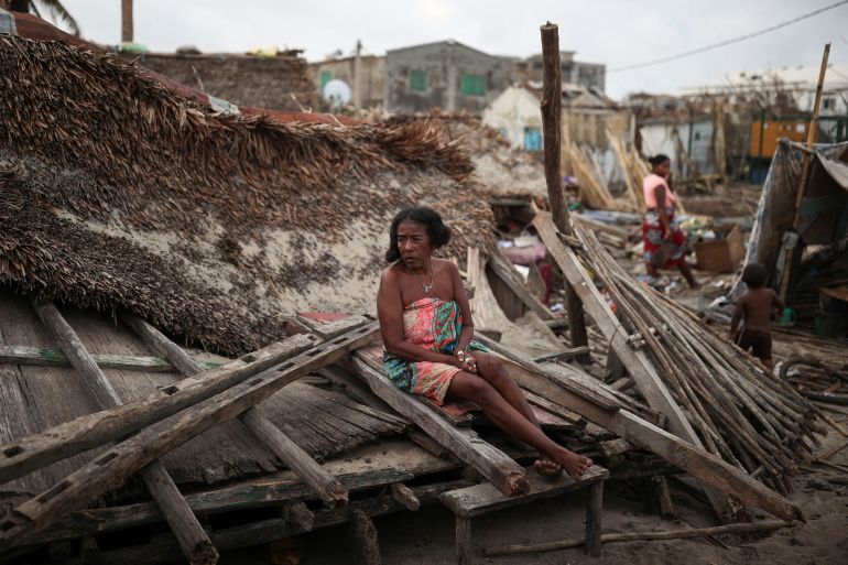 A woman sits on the debris of her destroyed house in the aftermath of Cyclone Batsirai