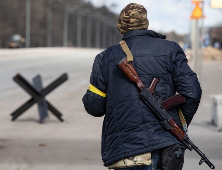 A member of the Territorial Defence Forces of Ukraine is seen at a checkpoint on the outskirts of Kyiv