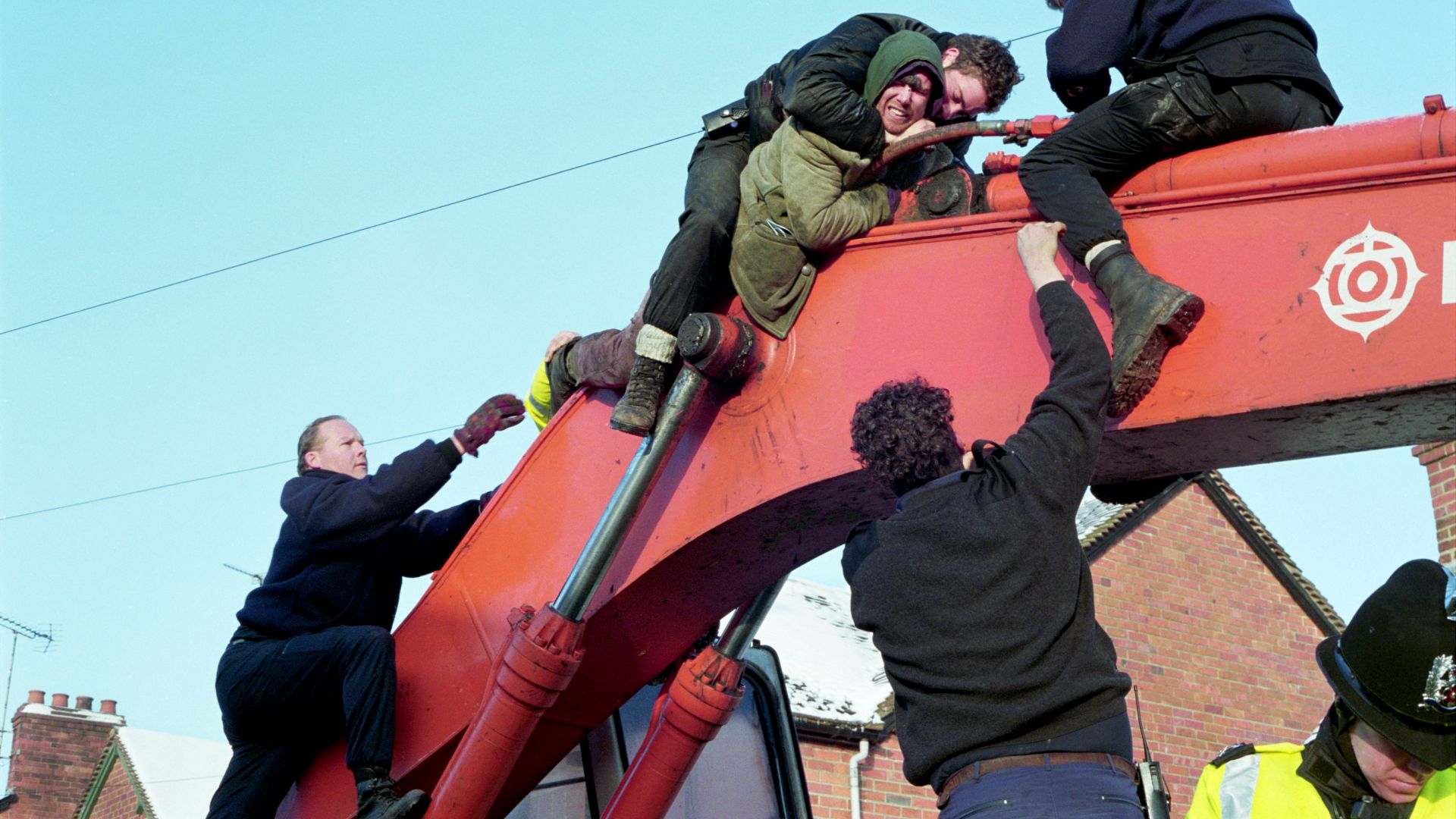 An activist is tackled by police machinery