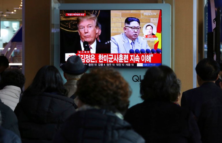 People watch a TV screen showing North Korean leader Kim Jong Un and U.S. President Donald Trump in 2018.