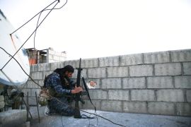 A soldier with the US-backed Syrian Democratic Forces takes cover