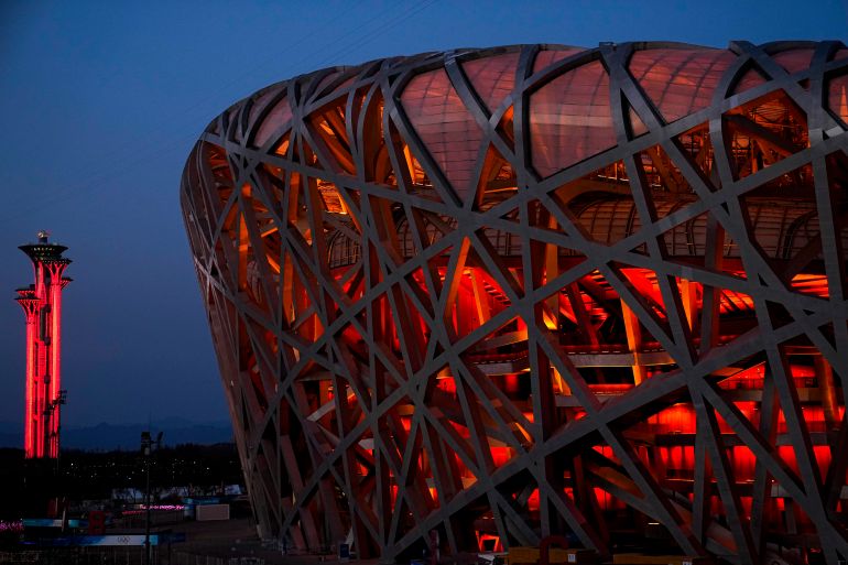 The National Stadium and the Beijing Olympic Tower are lit in red