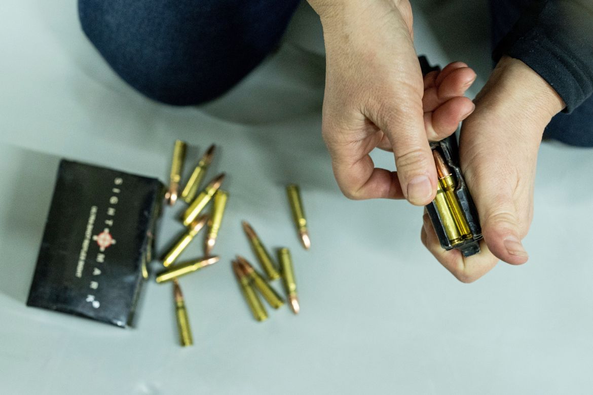 A woman loads ammunition for a Kalashnikov assault rifle during training