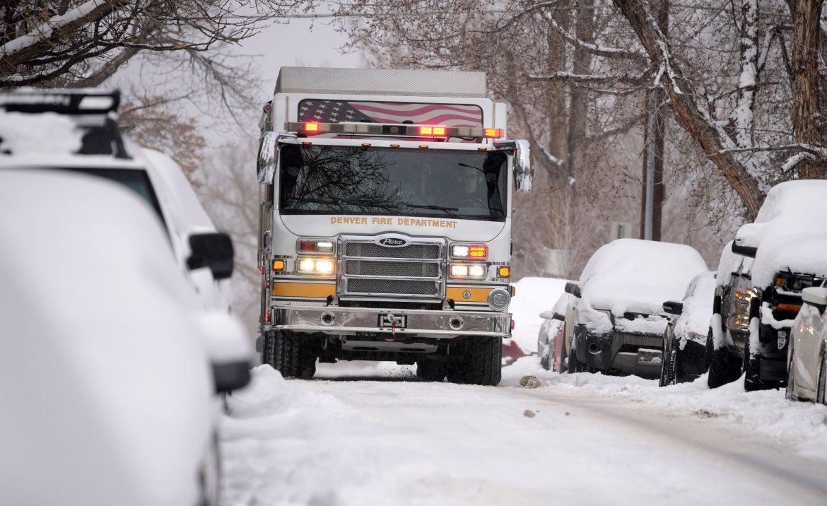 A Denver Fire Department truck heads to an emergency call along South Washington Street as a winter storm sweeps over the intermountain West