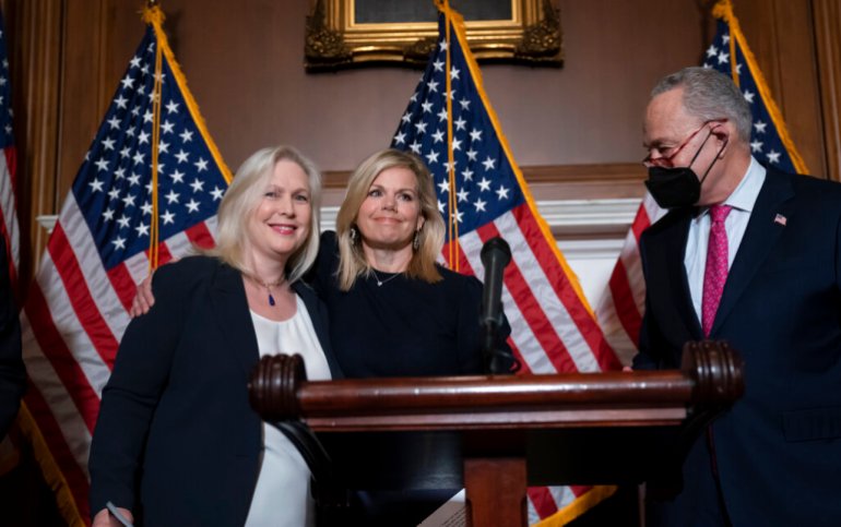 Former Fox News anchor Gretchen Carlson, center, celebrates with Sen. Kirsten Gillibrand, D-N.Y., left, and Senate Majority Leader Chuck Schumer, D-N.Y., after Congress gave final approval to legislation guaranteeing that people who experience sexual harassment.