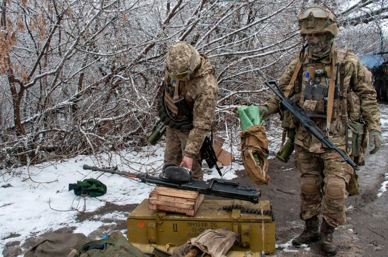 Ukrainian soldiers handle equipment outside Kharkiv,