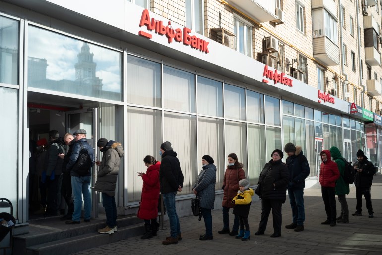 People stand in line to withdraw money from an ATM of Alfa Bank in Moscow
