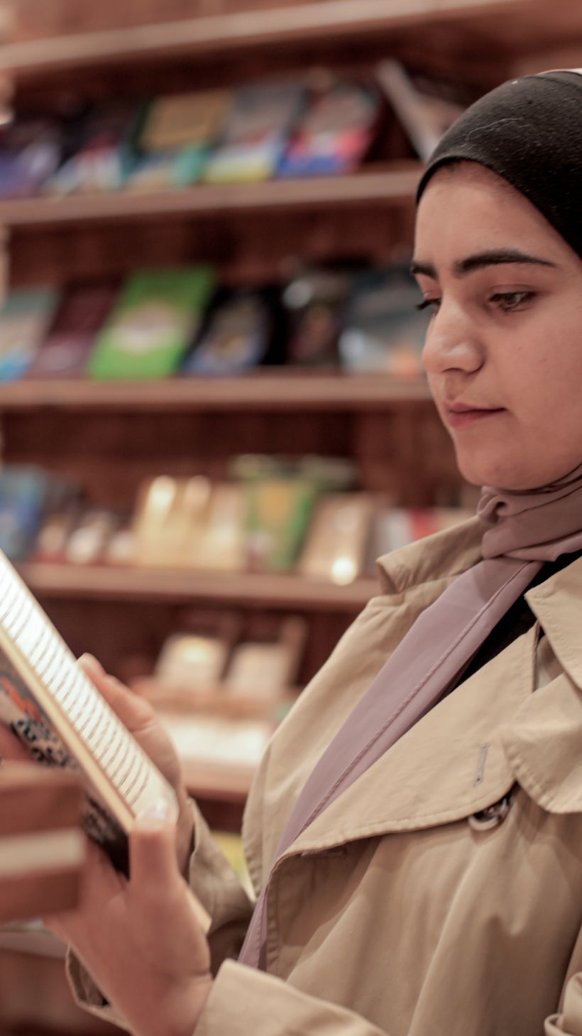 A young woman reads through a book