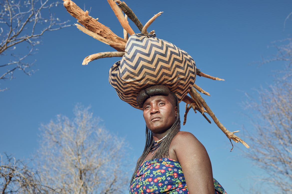 A photo of a woman with a bag and twigs on her head.