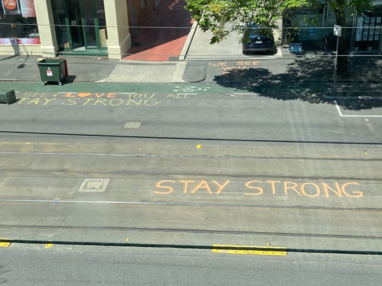 Messages of support written on the road outside the Park Hotel so those inside can read them , including Stay Strong written in orange capital letter between the tram lines and a heart reading love
