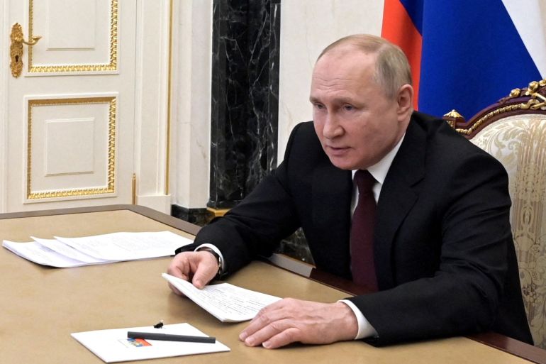 Russian President Vladimir Putin is seen signing a decree