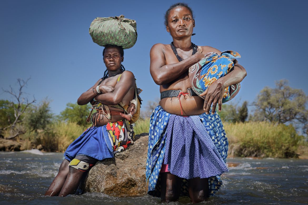 A photo of two women standing in a river.