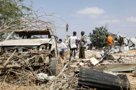 People survey their destroyed homes and cars following an al-Shabab attack in Mogadishu, Somalia, that killed five people.